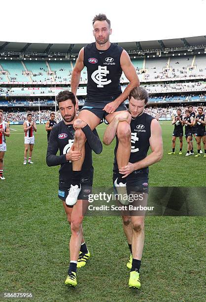 Andrew Walker of the Blues is chaired from the field by Kade Simpson of the Blues and Bryce Gibbs of the Blues as he leaves the field after playing...