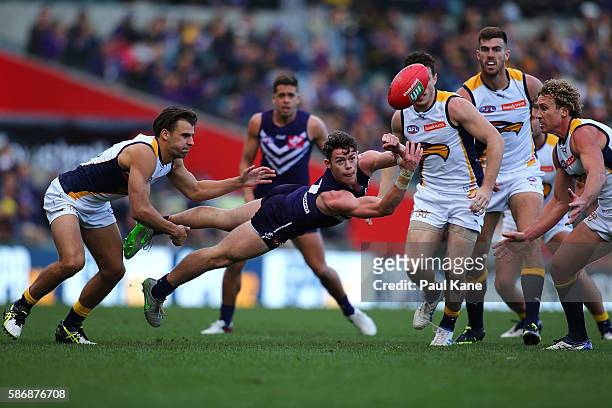 Lachie Neale of the Dockers handballs during the round 20 AFL match between the Fremantle Dockers and the West Coast Eagles at Domain Stadium on...