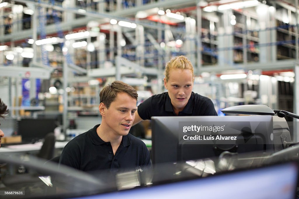 Employees using computer in logistics warehouse