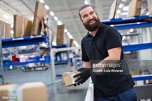 cheerful employee working in logistics center - männer über 30 stock-fotos und bilder