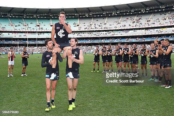 Andrew Walker of the Blues is chaired from the field by Kade Simpson of the Blues and Bryce Gibbs of the Blues as he leaves the field after playing...