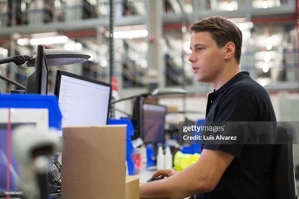 Employee using computer in logistics center