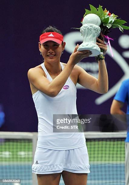 Duan Yingying of China poses with her trophy after winning the singles final match against Vania King of the US at the Jiangxi Open WTA tennis...