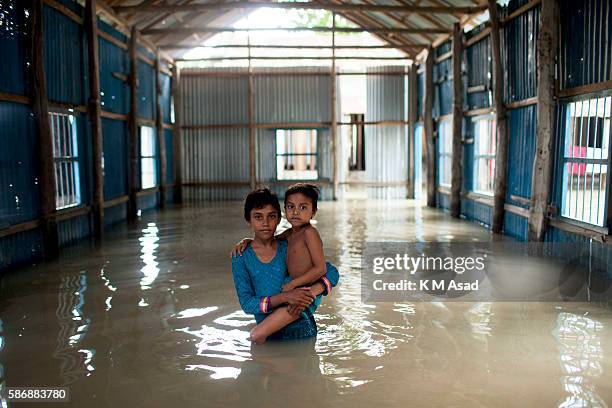 Children stand in the floodwater at Kurigram. Bangladesh has been suffering from devastating monsoon floods from the middle of July. Causes of global...