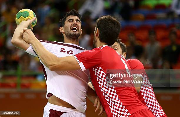 Kamal Aldin Mallash of Qatar tries to shoot against Marko Kopljar of Croatia during the Mens Preliminary Group A match between Croatia and Qatar on...