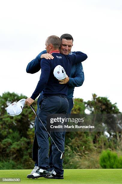 Anthony Wall of England is congratulated by Alex Noren of Sweden after he won their match on hole 18 on day four of the Aberdeen Asset Management...