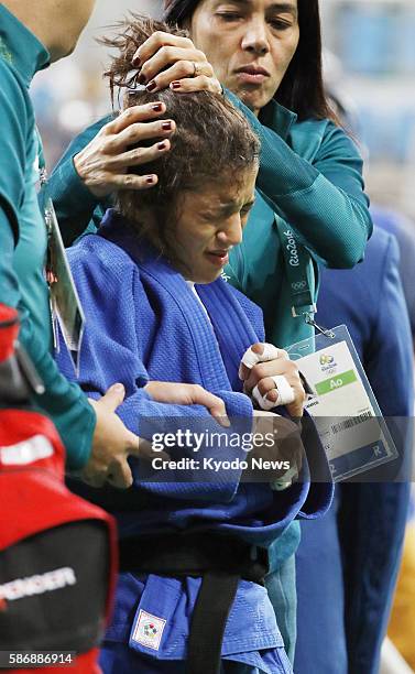 London Olympics gold medalist Sarah Menezes of Brazil is consoled by her coach after being defeated by Urantsetseg Munkhbat of Mongolia in the...