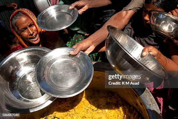 After being affected by the floodwater women take shelter in a high school building and come to take relief food at Dewangonj, Jamalpur. Bangladesh...