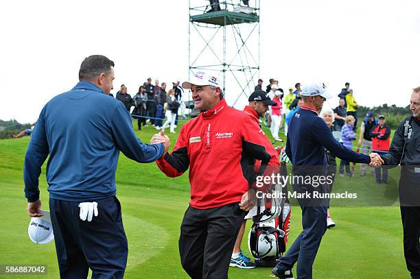 Anthony Wall of England is congratulated by tournament host Paul Lawrie of Scotland after his win in the final match on day four of the Aberdeen...