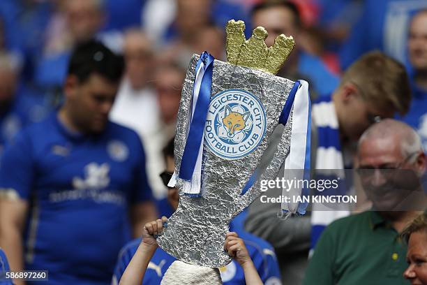 Leicester City fan holding a homemade replica of the Premier League trophy waits for kick off of the FA Community Shield football match between...