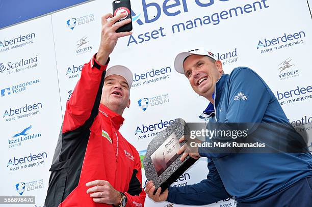 Anthony Wall of England gets a selfie with his winners trophy and tournament host Paul Lawrie of Scotland on day four of the Aberdeen Asset...