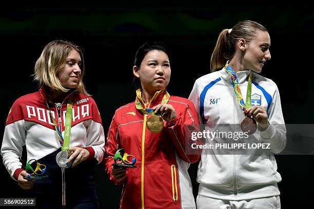 Silver medallist Russia's Vitalina Batsarashkina, gold medal winner China's Zhang Mengxue and bronze medallist Greece's Anna Korakaki stand on the...