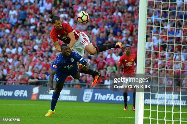 Manchester United's Swedish striker Zlatan Ibrahimovic beats Leicester City's English defender Wes Morgan to head in their second goal during the FA...