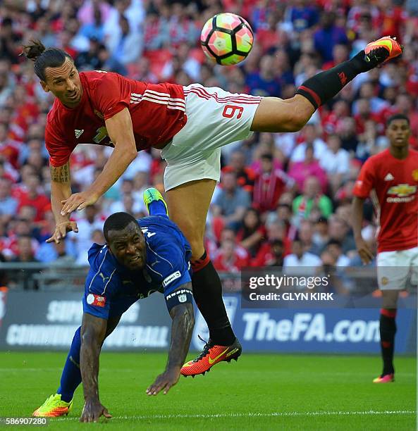 Manchester United's Swedish striker Zlatan Ibrahimovic beats Leicester City's English defender Wes Morgan to head in their second goal during the FA...