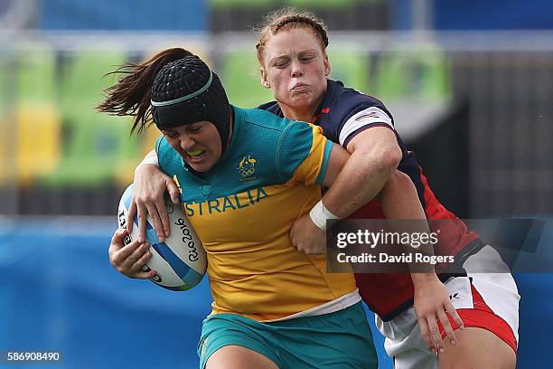 Sharni Williams of Australia carries the ball under pressure against Alev Kelter of the United States during the Women's Pool A rugby match on Day 2...