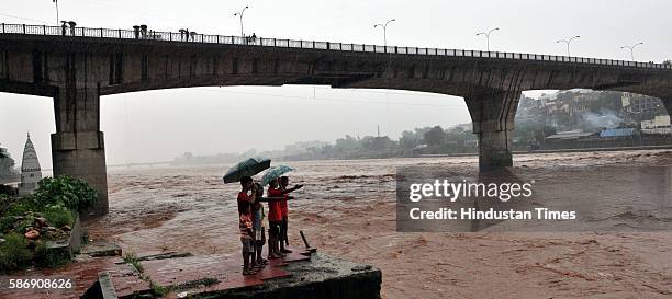 Children standing on the bank of the overflowing Tawi River, on August 7, 2016 in Jammu, India. Authorities sounded a flood alert on Sunday after...