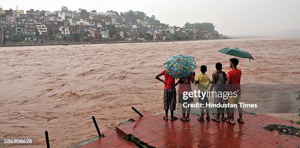 Children standing on the bank of the overflowing Tawi River, on August 7, 2016 in Jammu, India. Authorities sounded a flood alert on Sunday after...