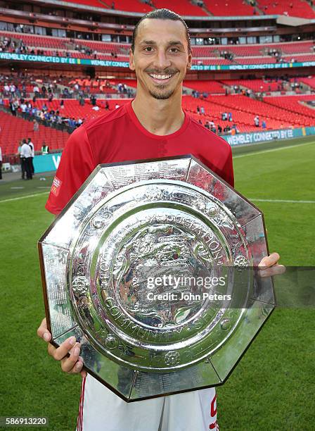 Zlatan Ibrahimovic of Manchester United poses with the Community Shield trophy in the dressing room after the FA Community Shield match between...