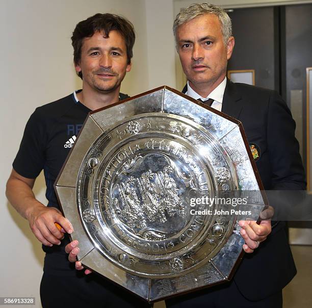 Assistant Manager Rui Faria and Manager Jose Mourinho of Manchester United pose with the Community Shield trophy in the dressing room after the FA...