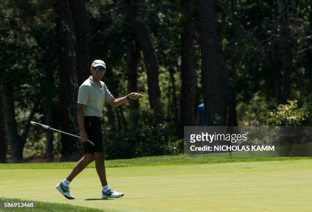 President Barack Obama reacts to his putt on the first green as he plays golf at Farm Neck Golf Club in Oak Bluffs, Massachusetts on the island of...