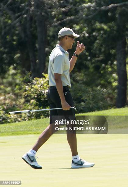 President Barack Obama reacts to his putt on the first green as he plays golf at Farm Neck Golf Club in Oak Bluffs, Massachusetts on the island of...
