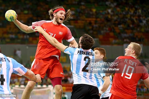 Mikkel Hansen of Denmark shoots at goal past Federico Fernandez of Argentina during the Mens Preliminary Group A match between Denmark and Argentina...
