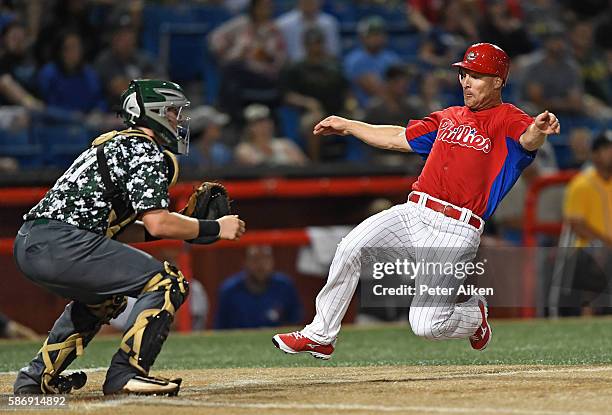 Base runner Pete Orr of the Kansas Stars slides home with a run past catcher Riley Baasch of the Colorado Xpress in the seventh inning during the NBC...