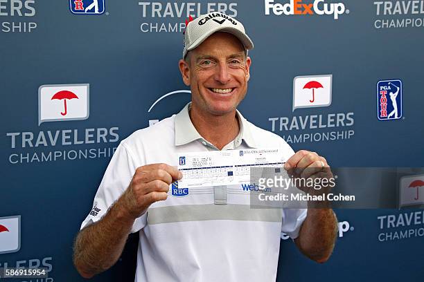 Jim Furyk of the United States poses with his scorecard after shooting a record setting 58 during the final round of the Travelers Championship at...