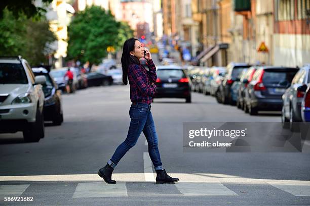 donna che usa telefono stockholm city street sullo sfondo - attraversare foto e immagini stock