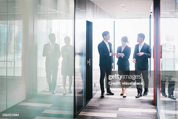 three entrepreneurs briefing in the office - meeting candid office suit stockfoto's en -beelden