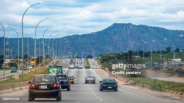 african landscape and highway traffic. abuja, nigeria. - abuja 個照片及圖片檔