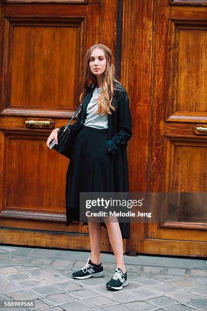 Danish model Amalie Moosgaard wears a black jacket and skirt, a gray top, and black New Balance sneakers after Alberta Ferretti on Day 1 of Couture...