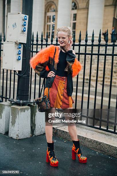 Belgian model Hanne Gaby wears a orange, black, and animal print fur sweater, a red and orange suede striped button-up skirt, a paisley-print purse,...