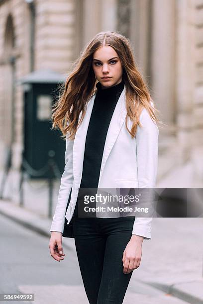 Dutch model Estella Boersma wears a button-less white blazer over a black turtleneck and jeans after the Alberta Ferretti show on Day 1 of Couture FW...