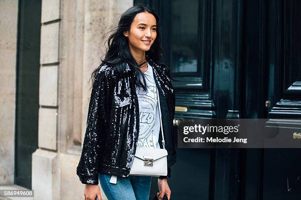 Chinese model Luping Wang wears a black sequined jacket and a white Prada purse after the Alberta Ferretti show on Day 1 of Couture FW 16 on July 03,...