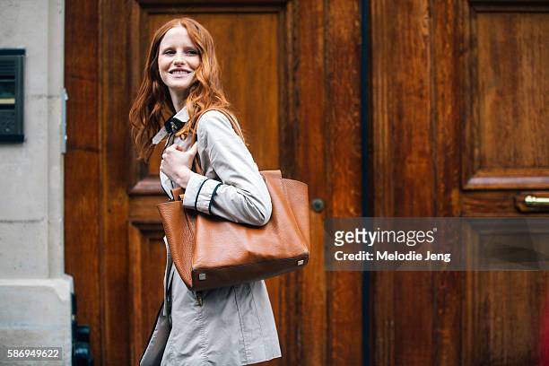 Polish model Magdalena Jasek wears a white peacoat and brown leather tote bag purse after the Alberta Ferretti show on Day 1 of Couture FW 16 on July...