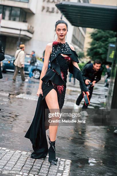 Italian supermodel Mariacarla Boscono wears an asymmetrical red and black draped and embellished Atelier Versace Fall/Winter 2016 couture dress and...