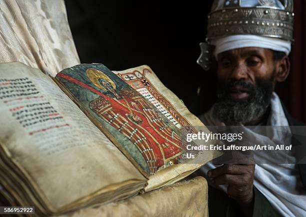 Ethiopian orthodox priest with an old bible in nakuto lab rock church, amhara region, lalibela, Ethiopia on February 23, 2016 in Lalibela, Ethiopia.