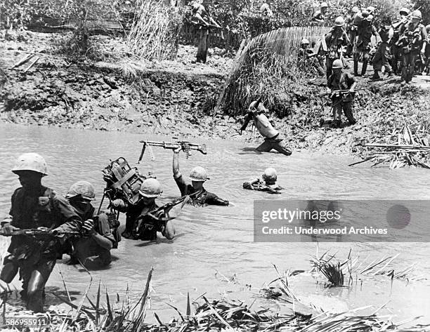 Members of the 9th Infantry Division move across a stream south of Saigon on a search and destroy mission, Mekong Delta, Viet Nam, 1967.
