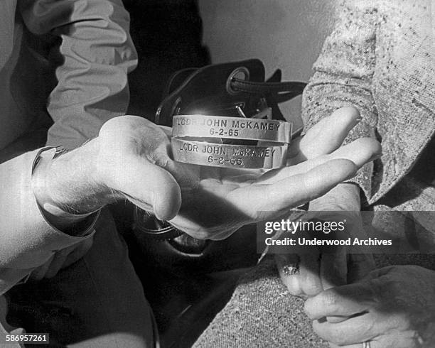 Navy Commander John McKamey accepts the POW bracelets from his parents during their reunion at the Naval Hospital in Oakland after his release from...