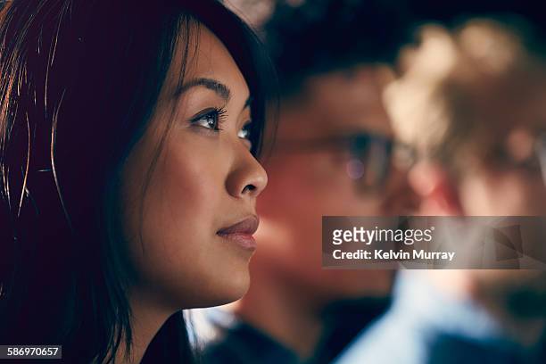 a young asian professional watches presentation - differential focus fotografías e imágenes de stock