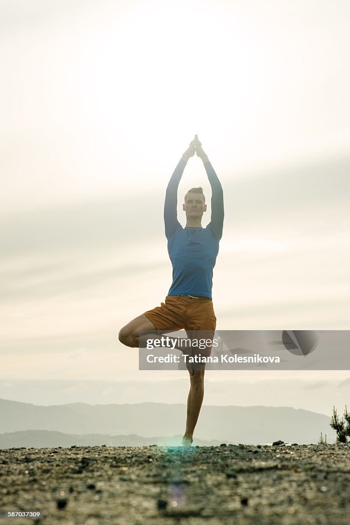 Man practicing yoga in the mountains