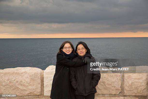 portrait of mother and daughter hugging - jean marc payet stock-fotos und bilder