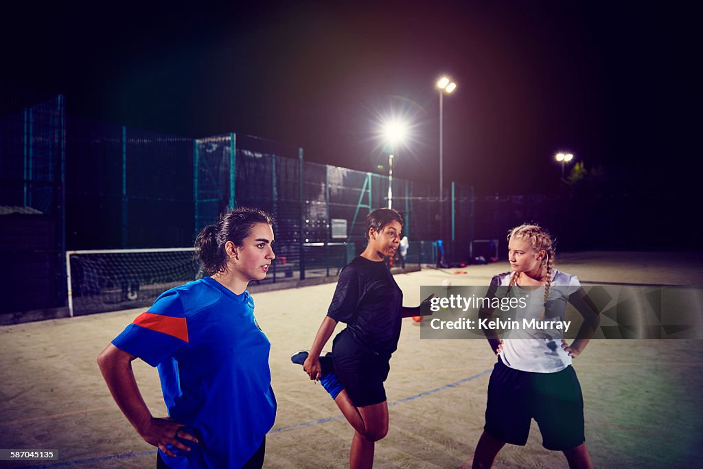 Female footballers stretch in training session