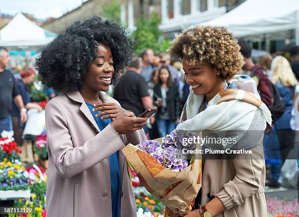 woman taking photos of flowers at flower market. - flower market stock pictures, royalty-free photos & images