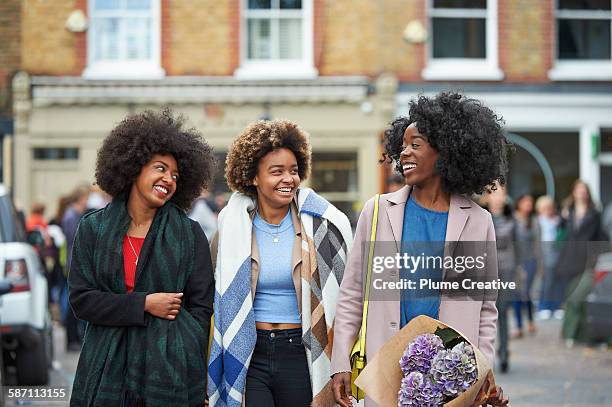 group of friends walking down london street. - down coat stock-fotos und bilder