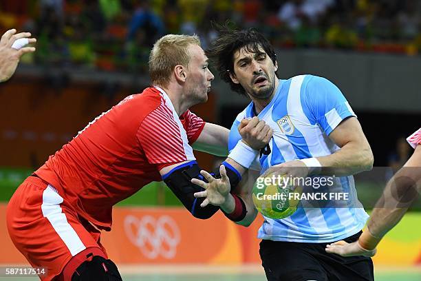 Denmark's pivot Rene Hansen vies with Argentina's right back Federico Vieyra during the men's preliminaries Group A handball match Denmark vs Germany...