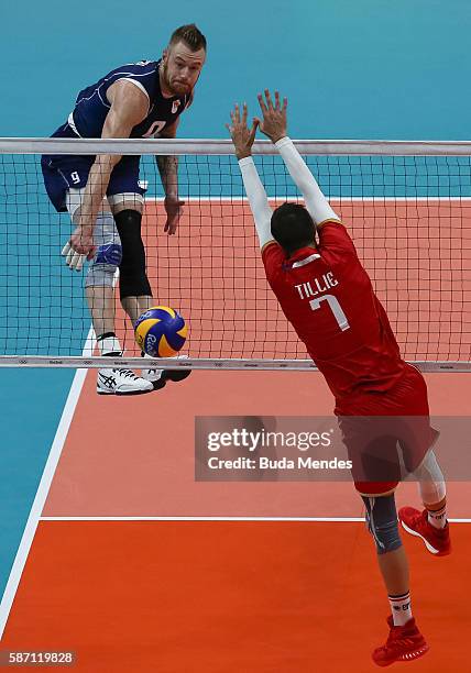 Ivan Zaytsev of Italy spikes the ball against Kevin Tillie Kevin of France during the Men's Preliminary Pool A match between the Italy and France on...