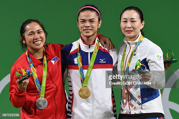 Tawain's gold medallist Hsu Shu-Ching , Philippines' silver medallist Hidilyn Diaz and South Korea's bronze medallist Yoon Jin Hee pose on the podium...