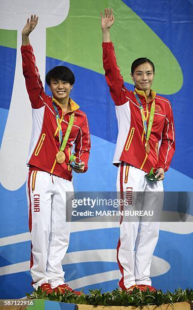 Gold medallists China's Wu Minxia and Shi Tingmao celebrate during the podium ceremony of the Women's Synchronized 3m Springboard final event at the...